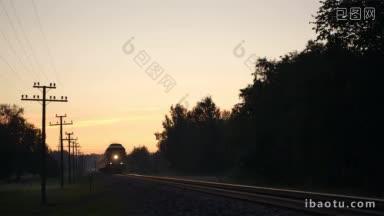 夕阳西下，亮着前灯的客运列车在乡间缓缓驶过